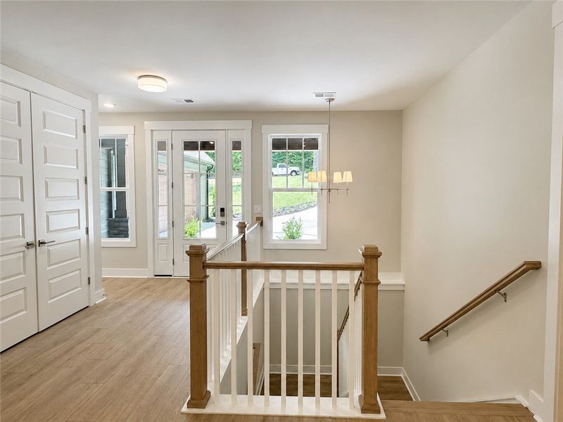 A well-lit entry with rich wood flooring and a cla A well-lit entry with rich wood flooring and a cla