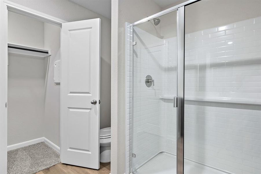 Full bathroom featuring a shower stall and wood finished floors