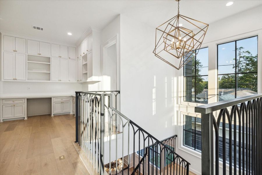 View of stairway chandelier and study nook upstairs. Check out the detail in the stair railing.*Picture is of a recently constructed home by the builder.  1519 Candlelight will be similar in quality, but these pictures are not meant to be an exact representation of the new home. Specs of home may change at sole discretion of the seller.