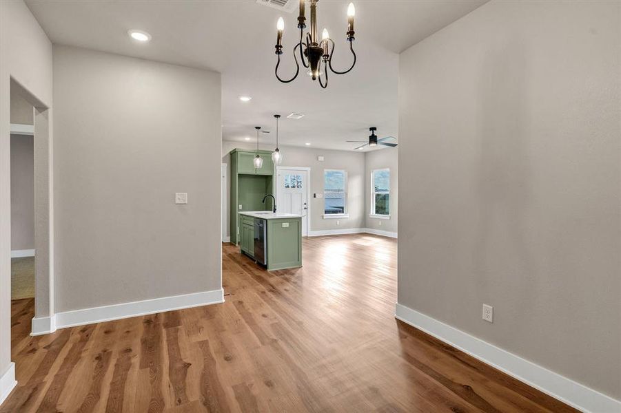Unfurnished dining area featuring recessed lighting, dark wood-style flooring, a chandelier, ceiling fan, and arched walkways