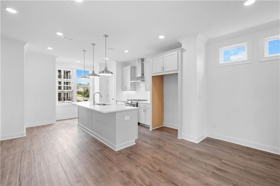 Kitchen featuring White cabinetry, pendant lighting, dark wood-style flooring, an island with sink, and recessed lighting ** Pic of previously built home for reference only, not actual home ** Kitchen featuring White cabinetry, pendant lighting, dark wood-style flooring, an island with sink, and recessed lighting ** Pic of previously built home for reference only, not actual home **
