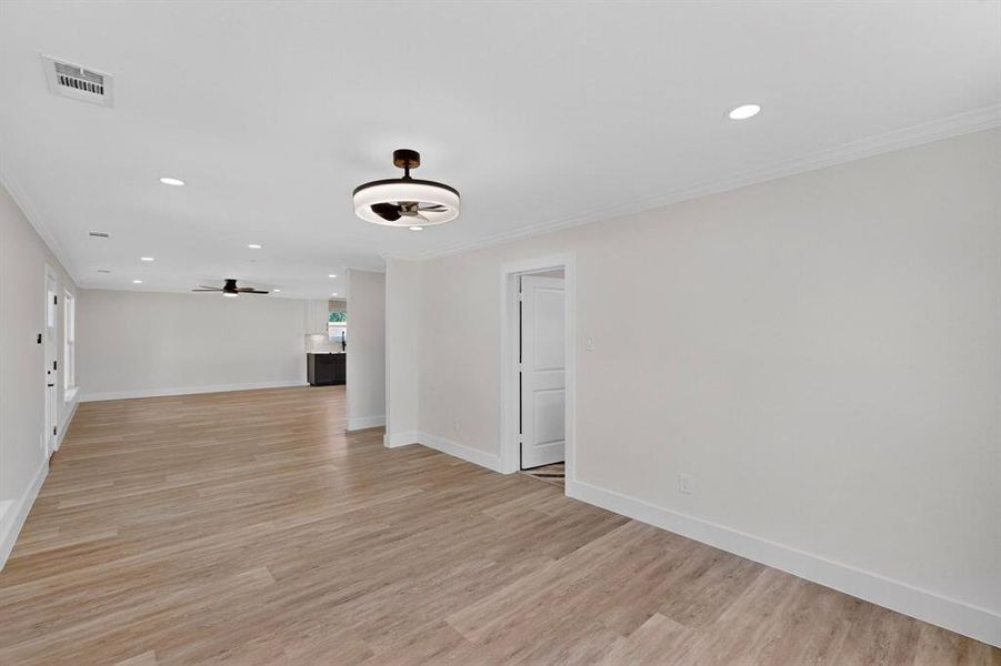 Unfurnished living room with recessed lighting, light wood-style floors, a ceiling fan, and ornamental molding