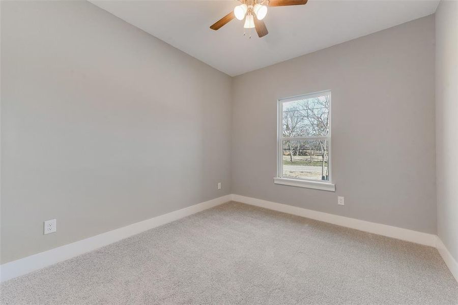 Carpeted empty room featuring ceiling fan