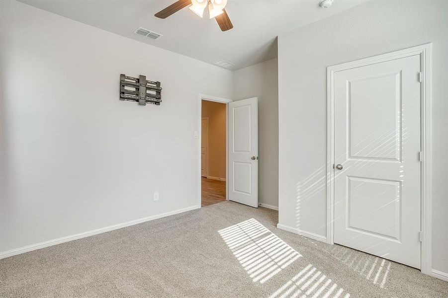 Unfurnished bedroom featuring light carpet and ceiling fan