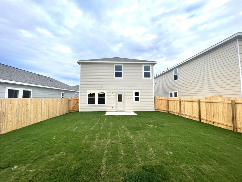 Rear view of property with a lawn and a fenced backyard