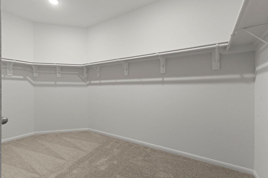 The massive walk-in closet provides exceptional storage space with built-in shelving and open hanging areas. There’s plenty of room to keep your wardrobe organized and accessible in this beautifully designed primary suite.