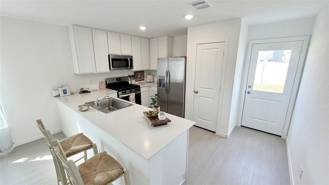 Bright view of the kitchen extending toward the back door, with opens to the spacious backyard. Bright view of the kitchen extending toward the back door, with opens to the spacious backyard.