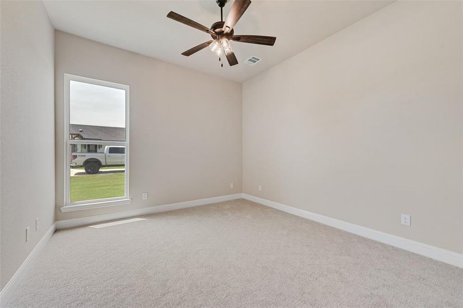 Unfurnished room with carpet flooring, healthy amount of natural light, and ceiling fan