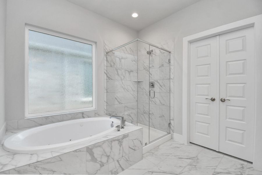 Indulge in a spa-like retreat within the confines of this primary bathroom. Delight in a spacious walk-in shower enveloped in stylish tile surround and unwind in a separate garden tub adorned with custom detailing. Indulge in a spa-like retreat within the confines of this primary bathroom. Delight in a spacious walk-in shower enveloped in stylish tile surround and unwind in a separate garden tub adorned with custom detailing.