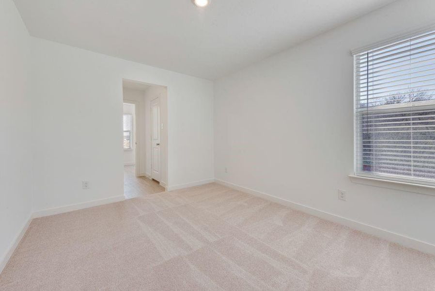 Spare room with light carpet and baseboards Spare room with light carpet and baseboards