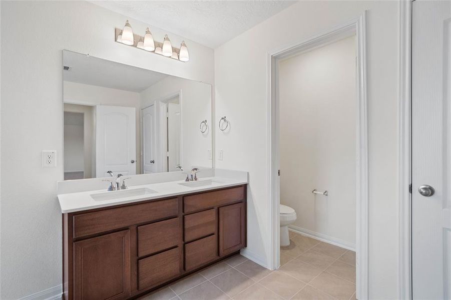 This primary bathroom is definitely move-in ready! Featuring stained cabinets with light countertops, dual vanities, high ceilings, neutral paint, sleek and modern finishes.