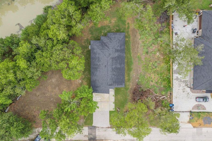 Detached single-family residence with a dark shingle roof and a concrete driveway Detached single-family residence with a dark shingle roof and a concrete driveway
