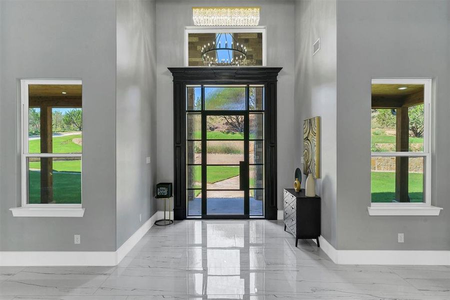 Entrance foyer featuring a towering ceiling and a notable chandelier