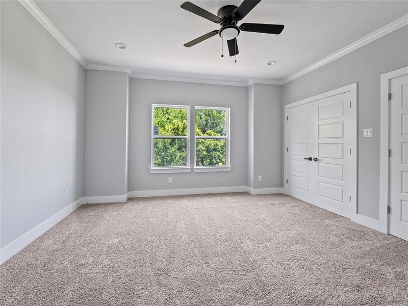 Unfurnished bedroom with ornamental molding, carpet floors, baseboards, and ceiling fan