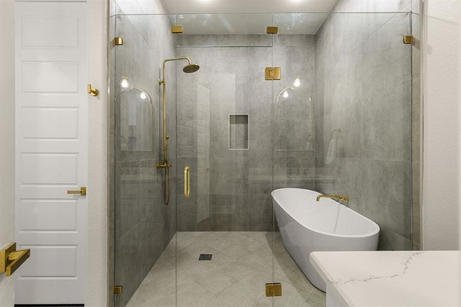 Bathroom featuring a stall shower, a soaking tub, and vanity