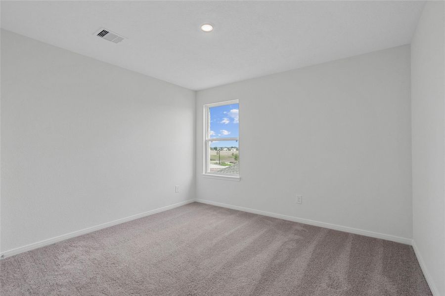 This secondary bedroom offers comfort and style with plush carpeting, neutral paint tones, recessed lighting, a large window, and a generously sized closet. This secondary bedroom offers comfort and style with plush carpeting, neutral paint tones, recessed lighting, a large window, and a generously sized closet.