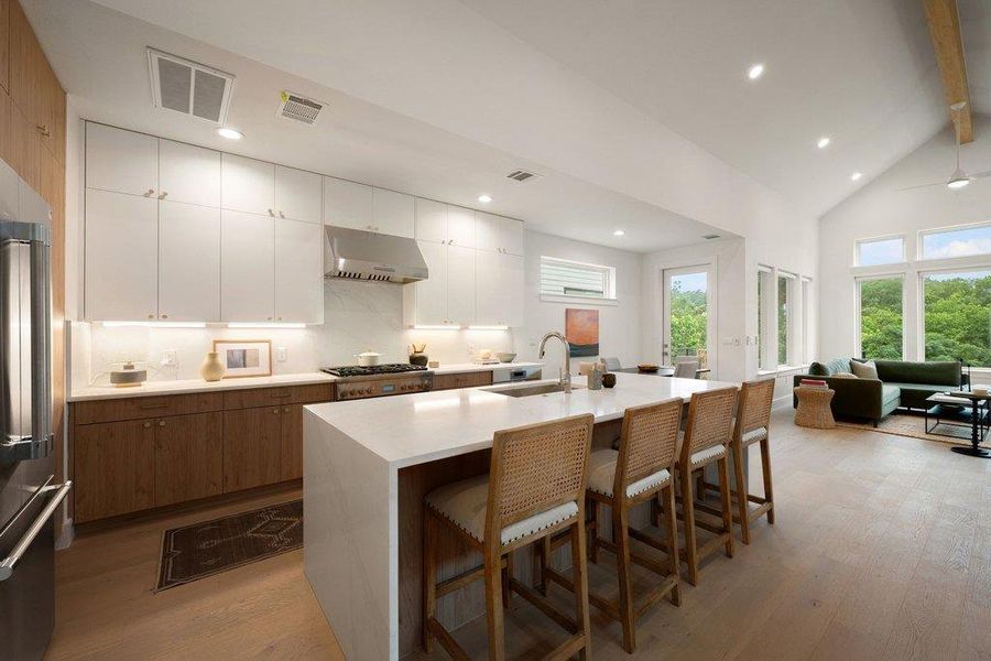 Culinary delights await in this light-filled kitchen, seamlessly flowing into a cozy living area with wooded views. Culinary delights await in this light-filled kitchen, seamlessly flowing into a cozy living area with wooded views.