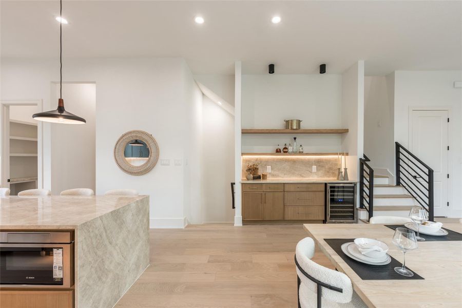Every element on this wall sits with intention. The beverage station is recessed into its own niche, the oak cabinetry carries the rhythm set by the kitchen, and the stair reads as sculpture rather than circulation. Good design is what you stop noticing...because it's doing its job.