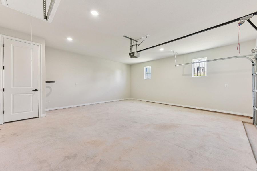 Garage with recessed lighting and baseboards