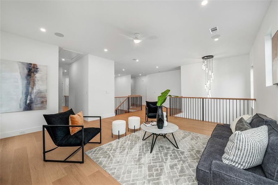 Sitting room with wood finished floors, ceiling fan, an upstairs landing, and recessed lighting Sitting room with wood finished floors, ceiling fan, an upstairs landing, and recessed lighting
