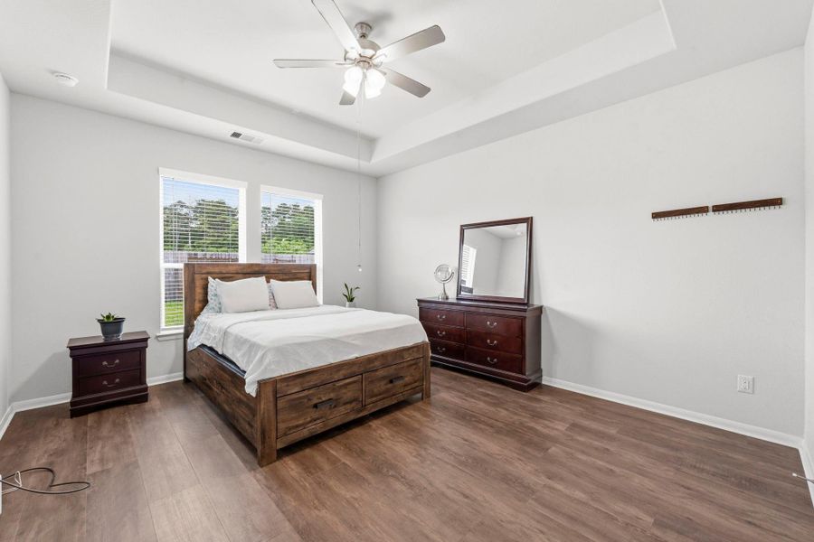 Unwind in your private primary retreat featuring tray ceilings, warm flooring, and generous space to relax. Unwind in your private primary retreat featuring tray ceilings, warm flooring, and generous space to relax.
