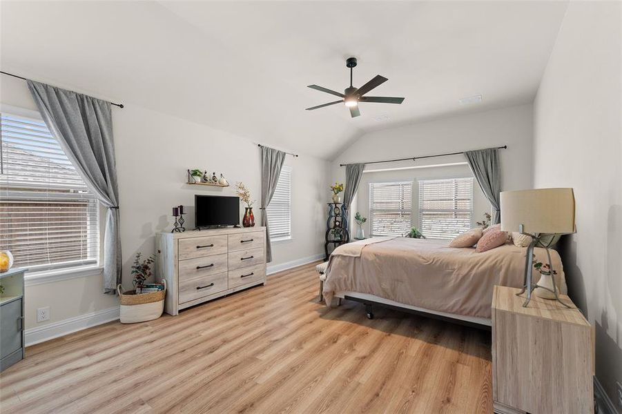 Bedroom featuring lofted ceiling, light wood finished floors, and a ceiling fan Bedroom featuring lofted ceiling, light wood finished floors, and a ceiling fan