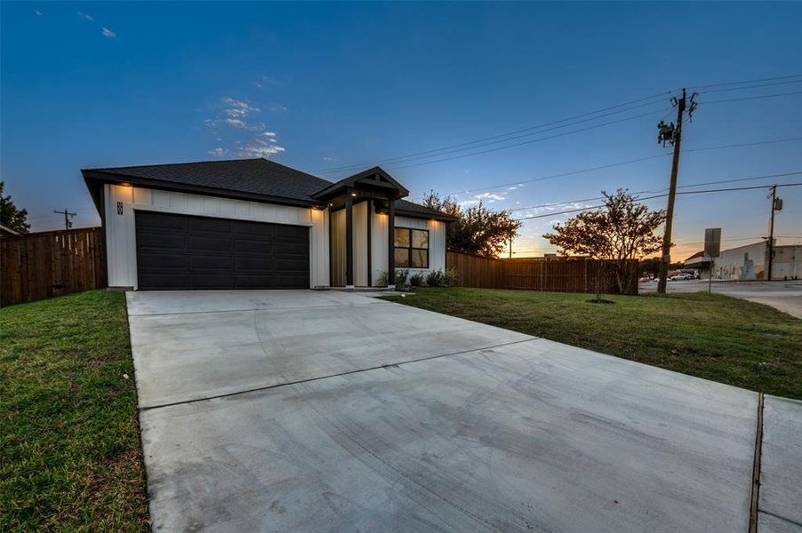 View of front of home featuring a garage and a yard