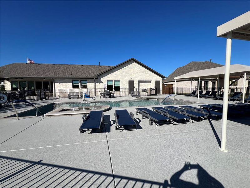 View of community swimming pool with a covered and non covered patio area.