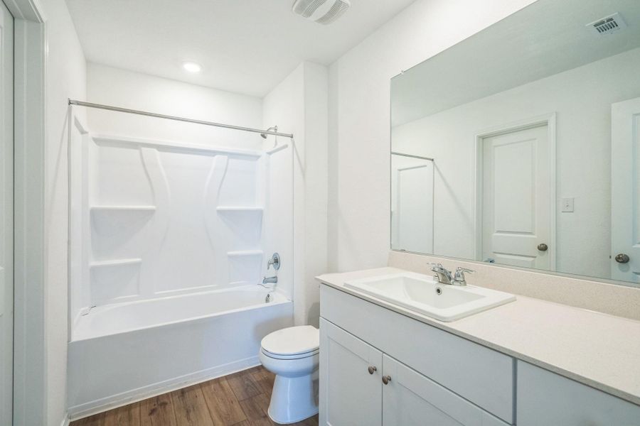 A well-appointed bath features a sleek vanity and a tub with an integrated shower. A well-appointed bath features a sleek vanity and a tub with an integrated shower.