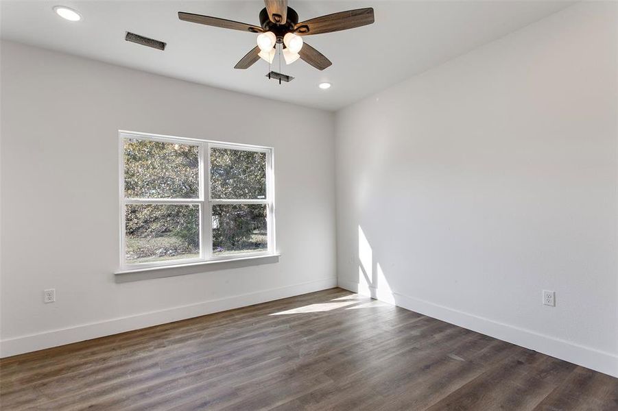 Spare room with dark hardwood / wood-style floors and ceiling fan