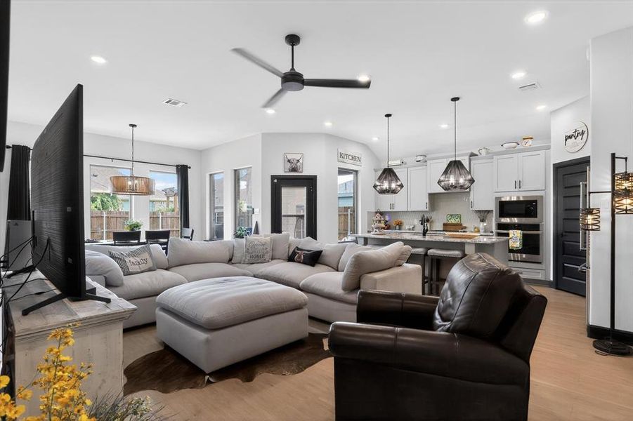 Open-concept living space featuring wood-finish flooring, recessed lighting, and a modern ceiling fan