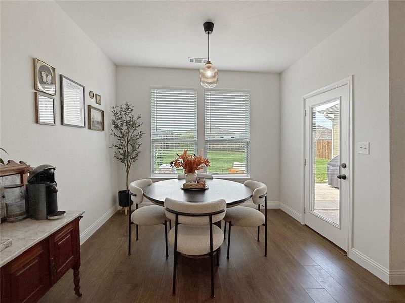 Dining space featuring dark wood-type flooring and baseboards Dining space featuring dark wood-type flooring and baseboards