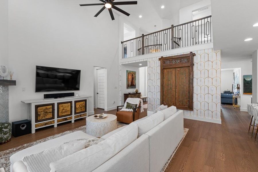 A grand living space features soaring ceilings, rich hardwood flooring, and a unique mezzanine overlooking the main area. A grand living space features soaring ceilings, rich hardwood flooring, and a unique mezzanine overlooking the main area.