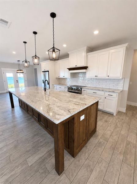 Expansive kitchen island featuring a light-toned countertop and dark wood-finish cabinetry Expansive kitchen island featuring a light-toned countertop and dark wood-finish cabinetry