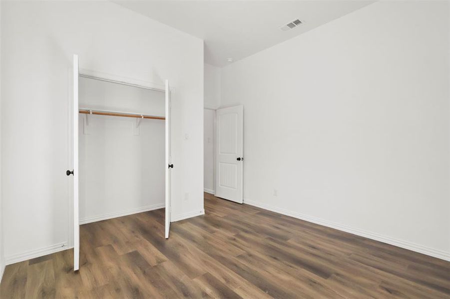 Unfurnished bedroom featuring a closet and dark hardwood / wood-style floors