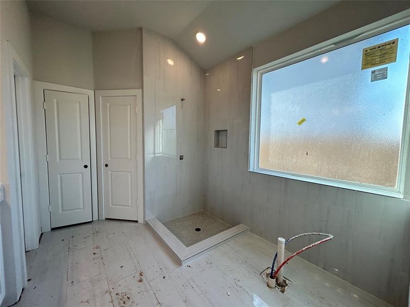 The main bathroom features sleek polished porcelain tiles that create a luxurious and contemporary feel. A stunning freestanding tub serves as the focal point, offering both style and relaxation.