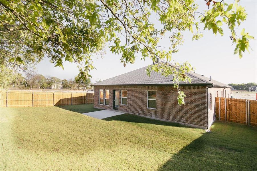 Rear view of house featuring a patio and a lawn