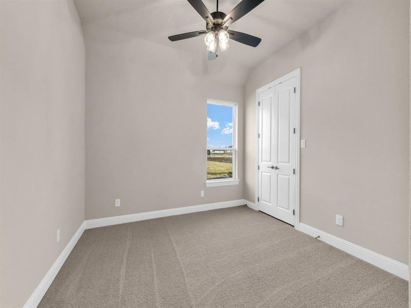 Carpeted spare room with ceiling fan