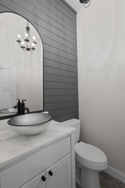 Half bathroom featuring vanity, a chandelier, and dark wood-style floors