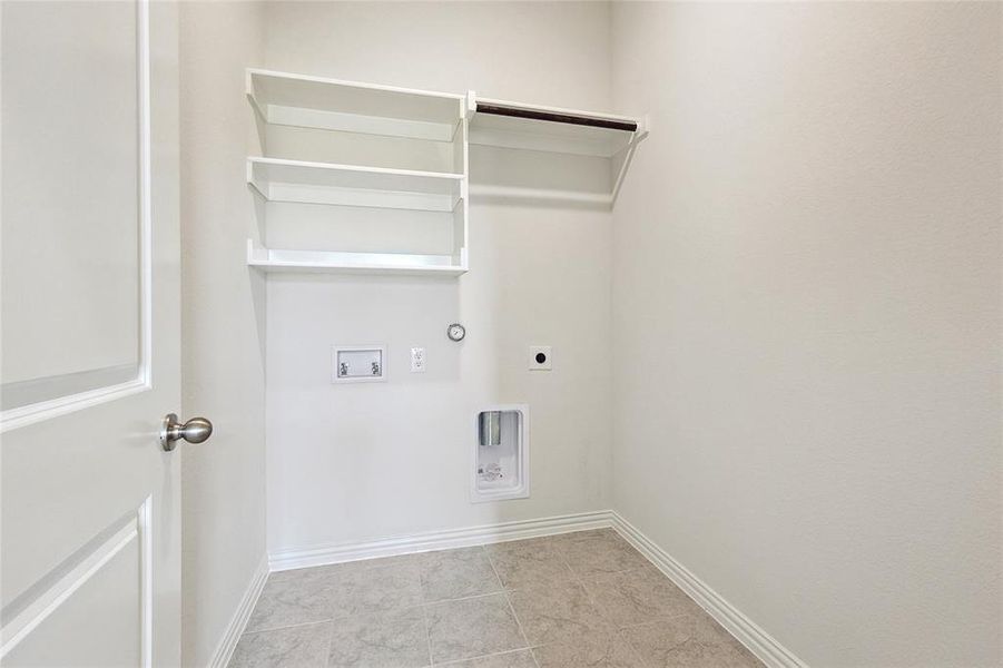 Washroom featuring electric dryer hookup, hookup for a gas dryer, hookup for a washing machine, and light tile patterned floors