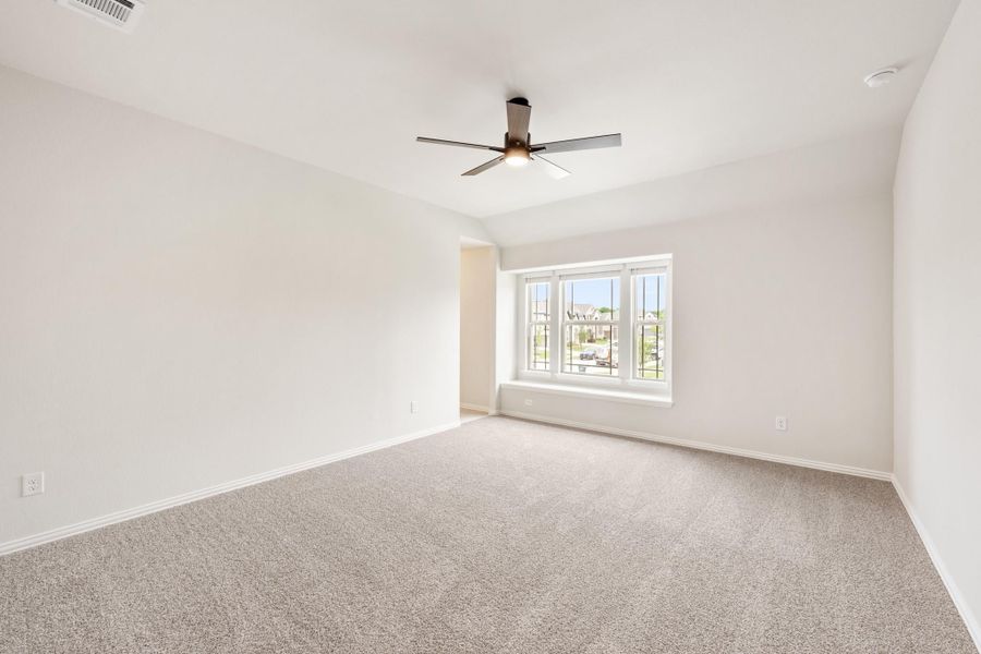 Empty bedroom with beige carpet, ceiling fan, and a triple window with natural light Empty bedroom with beige carpet, ceiling fan, and a triple window with natural light