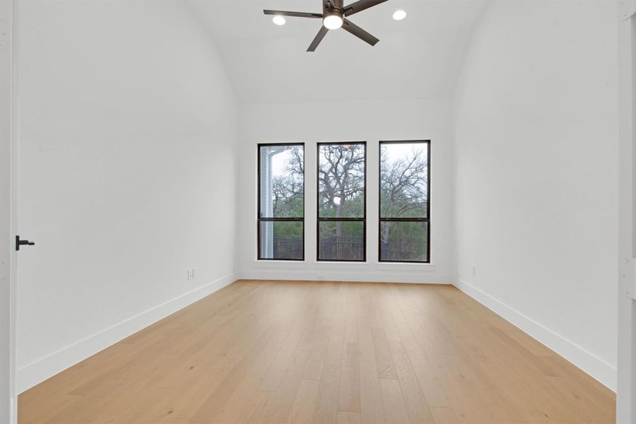 Flex Room featuring light hardwood flooring, high vaulted ceiling, ceiling fan, recessed lighting with scenic, greenbelt view