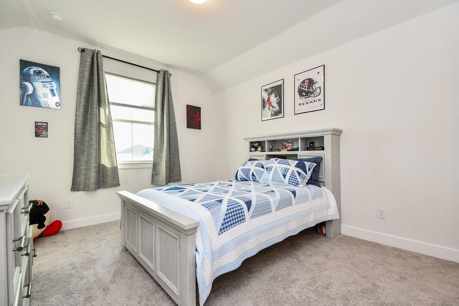 A roomy secondary carpeted bedroom welcomes both family and guests. A roomy secondary carpeted bedroom welcomes both family and guests.