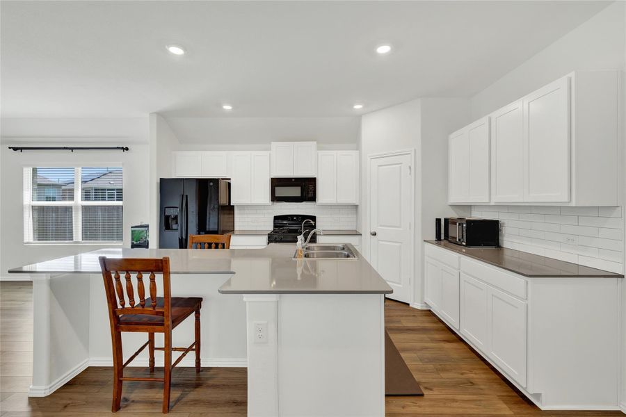 A well-appointed culinary space featuring bright white cabinetry and modern appliances.