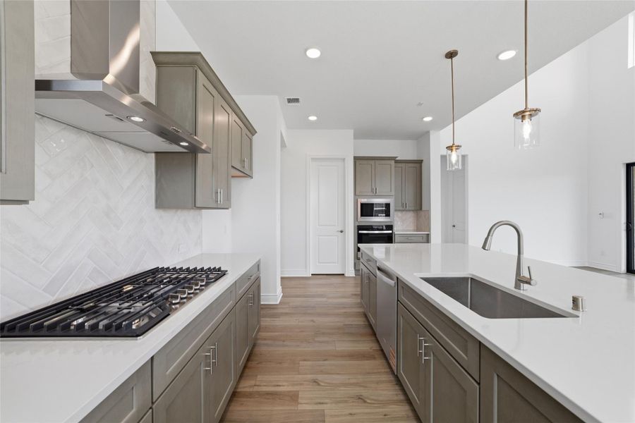 Modern, abundant cabinetry paired with elegant quartz countertops adds a luxurious and sophisticated touch to the home.