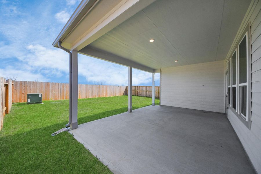 Experience outdoor living at its finest on this expansive covered patio, thoughtfully designed for BBQs and delightful outdoor dining. Sample photo of completed home with similar floor plan. Actual colors and selections may vary.