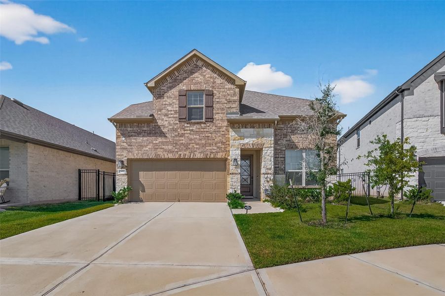 Front exterior of a new home in Sunterra, Katy, TX, highlighting curb appeal (Image 1).