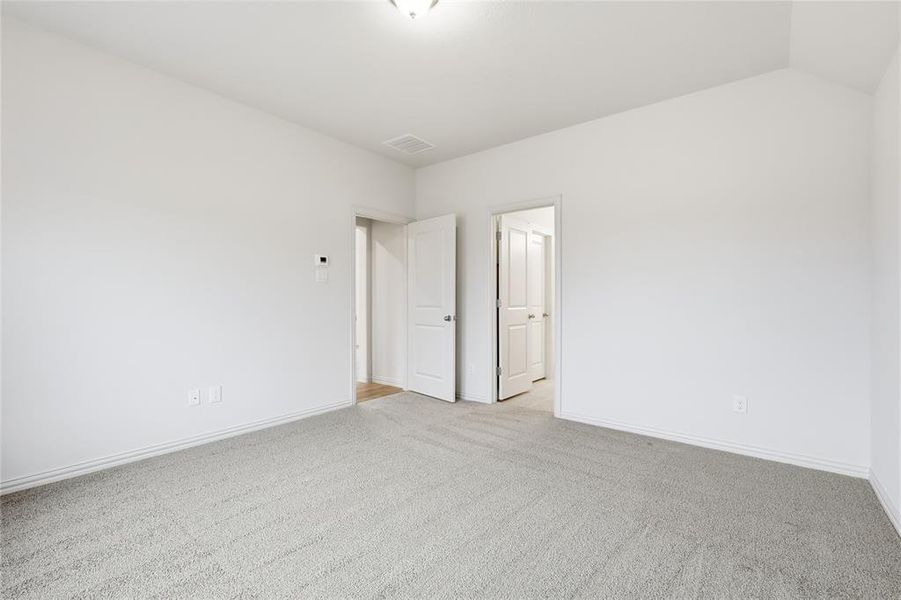 Spare room with carpet floors and lofted ceiling