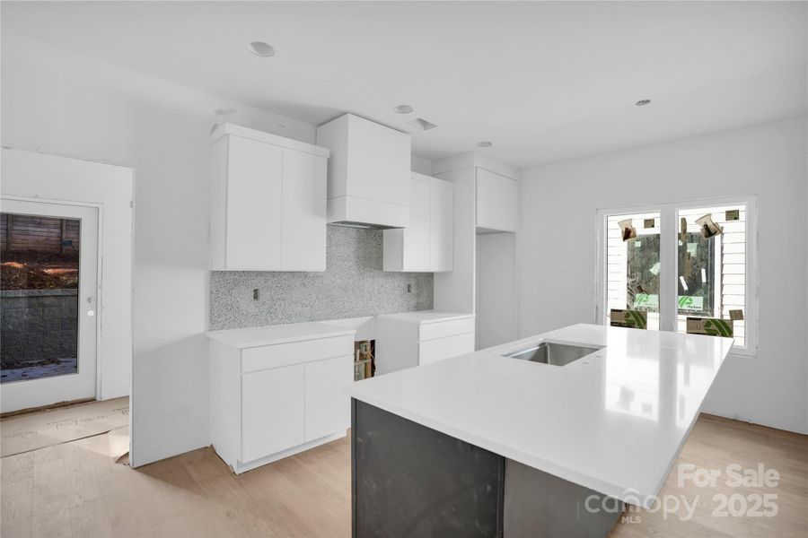Large kitchen with two-tone soft close cabinetry and quartz countertops. Still a bit dusty as we are finishing up construction!