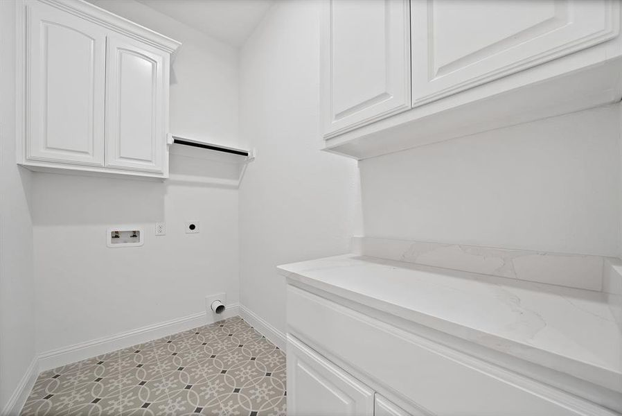 Laundry room featuring electric dryer hookup, cabinet space, washer hookup, and light tile patterned floors